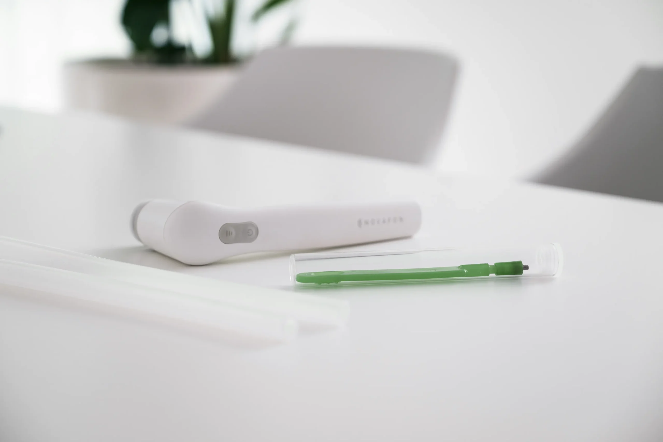 Therapiegerät und Stift auf einem Behandlungstisch in der Logopädie-Praxis