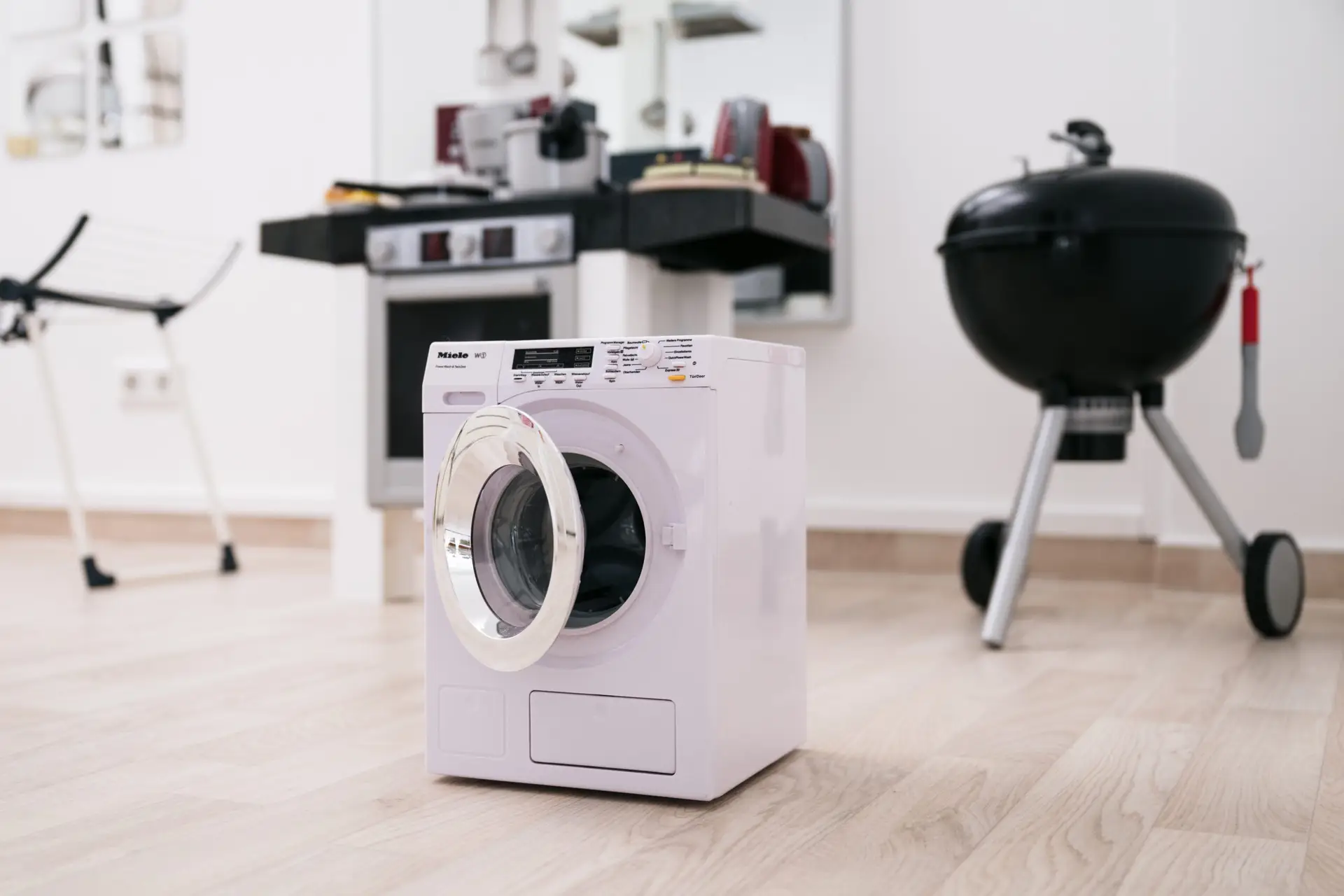 Spielzeug-Waschmaschine und Spielküche im Therapieraum für Kinder